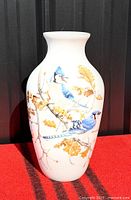 Front view of white porcelain vase showing blue jay design
