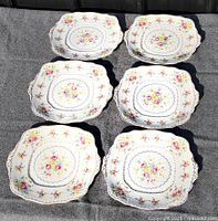 Six of the eight matching Royal Albert square plates displayed