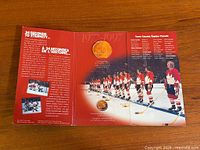 Tri-fold display card showing sterling silver coin and lapel pin