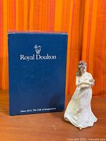 Figurine beside Royal Doulton box