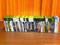 Row of Xbox 360 and Wii game cases with one loose disc
