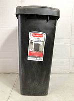 Front view of black Rubbermaid swing-top garbage bin