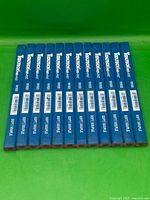 Twelve blue Tooltech Fat-Pat carpenter pencils laid out side by side on green background.