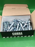 Open box showing numerous shiny sleeve anchors