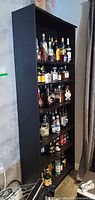 Full view of tall black bookcase with shelves