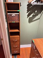 Tower with shelves, basket, three drawers next to dresser top