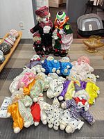 Group view of entire clown doll collection, two large standing and smaller dolls arranged in semicircle