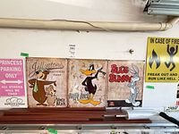 Four cartoon metal signs hanging on wall