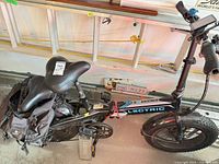 Folded Lectric bike with battery, pannier bag, lock visible