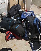Pile showing goalie pads, blocker, catcher glove, bag