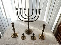 Full lot overview showing menorah center, two tall candlesticks, two small chambersticks