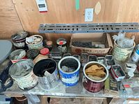 Work surface with all paint cans, tins and box of fasteners