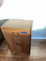Front view of oak veneer cabinet with closed drawer and doors