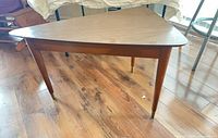 Full view of triangular coffee table showing top and legs