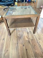 Front perspective of square wood and glass coffee table showing lower shelf