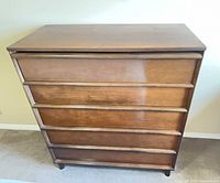 Front view of medium brown five-drawer dresser