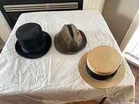 Three hats laid flat showing overall forms and materials