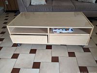 Coffee table front angle showing glass top, drawers, shelves, wheels