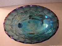 Top view of oval iridescent blue glass dish showing interior floral etching