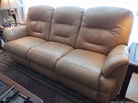 Front view of tan three-seat bonded leather sofa
