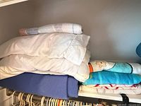 Stack of assorted folded towels on shelf