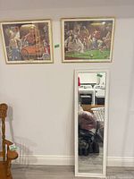 Both framed prints and mirror together on wall and floor