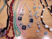 Overview of nine assorted necklaces laid out