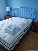 Full view of mattress, headboard, pillows, sheets and surrounding furniture