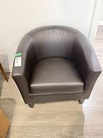 Front view of dark brown faux leather tub chair showing seat and arms