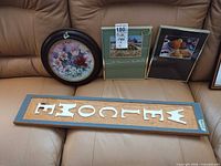 Overall view of framed decorative plate and two framed prints