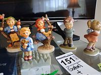 Group of five children figurines on glass table