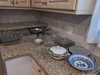 Assorted serveware displayed on countertop including Grimwades covered dish, hand-painted bowl, glass, crystal and metal pieces