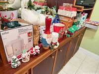 Shelf with boxed Braun juicer, Poppery popper, Avenue Noel box, stockings, figurines