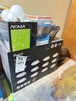 Assortment showing Illume 12-pack box, NOMA LED bulb box, Sylvania packaging on top