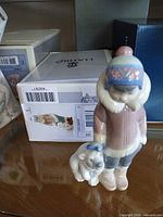 Front view of Lladró figurine beside original box