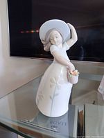 Front view of Lladró girl figurine with hat and flower pot