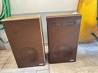 Front view of both Lloyd's speakers showing brown fabric grilles and cabinet condition