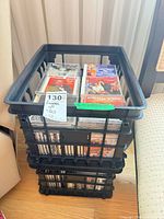 Three stacked black plastic crates filled with CDs and DVDs; visible titles The Waterboy and Erin Brockovich