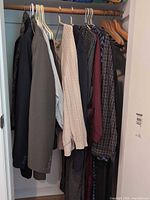 Closet view showing blazer, sweater and multiple shirts on hangers
