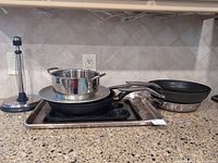 Group shot of all cookware and bakeware items stacked on countertop