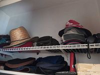Shelf with straw hat, bucket hats, scarves, gloves and umbrellas