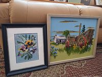 Both framed textile artworks side by side