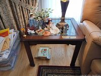 Mahogany wood end table with glass inset top, items on surface for scale