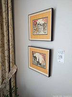 Both framed prints hanging on wall
