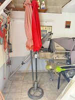Two closed patio umbrellas in cast iron stand