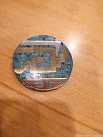 Front view of round silver and turquoise inlay brooch-pendant