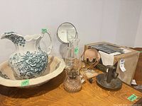 Pitcher, basin, oil lamp, vanity mirror with razor, electric lamp boxed, metal candle holder on wooden surface