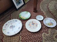 All five decorative plates laid out on carpet