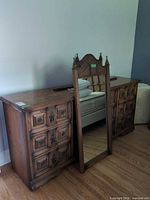 Long dresser with full-length mirror leaning against it and 3-drawer dresser at left