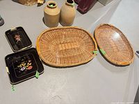 All items laid out: two wicker baskets, two stoneware crocks, two black floral trays